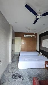 a bedroom with a large bed with a ceiling fan at MR.WHITE PRIME RESIDENCY in Chennai