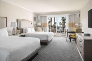 a hotel room with two beds and a desk at Hyatt Regency Huntington Beach Resort and Spa in Huntington Beach