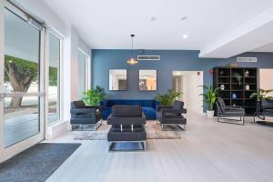 uma sala de estar com paredes e cadeiras azuis e um sofá em Garden Hotel Miami Airport, Trademark Collection by Wyndham em Miami