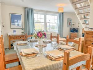 a dining room with a table with a vase of flowers at Harbour Life in Yarmouth