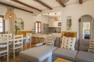 un salon et une cuisine avec un canapé et une table dans l'établissement Quinta do Marmeleiro - Casa Marmeleiro, à Santiago do Cacém