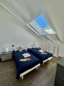 due letti in una stanza bianca con una finestra di Apt. Aries - Penthouse Menaggio a Menaggio Altre 31 foto