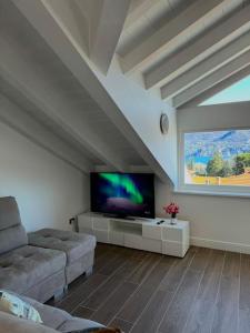 un soggiorno con una grande TV a schermo piatto di Apt. Aries - Penthouse Menaggio a Menaggio