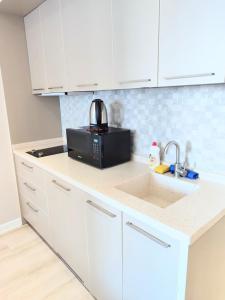 a kitchen with a sink and a microwave at Batumi - Premium Studio in Batumi