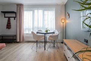 a dining room with a table and white chairs at Hotel de Duif Lisse - Keukenhof in Lisse