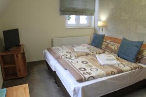 A bed or beds in a room at Zenit Panzió