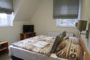 A bed or beds in a room at Zenit Panzió