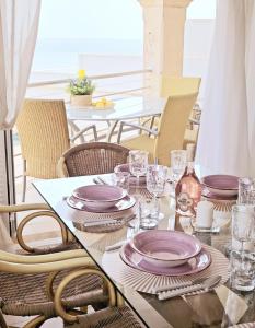 uma mesa com pratos roxos e copos em Casa Voramar em Cala d´Or