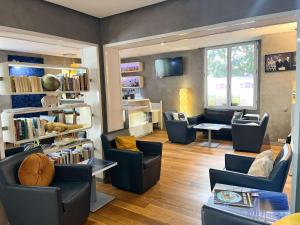 - un salon avec des canapés, des chaises et une table dans l'établissement ibis Styles Paris Tolbiac Bibliotheque, à Paris