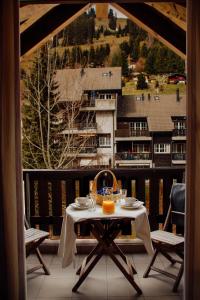 a table on a balcony with a view of a building at Andromède, appartements 2 à 5p de standing in Moleson