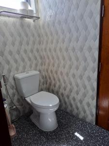 a bathroom with a toilet and a tiled wall at Seaview Eagles Nest Apartment 2 in Rawai Beach