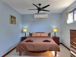 a bedroom with a bed with a ceiling fan at Seaview Eagles Nest Apartment 2 in Rawai Beach