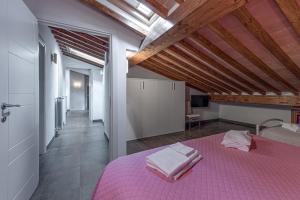 ein Schlafzimmer mit einem rosa Bett und einer Holzdecke in der Unterkunft Villa Moderna Resort in Borgo San Lorenzo + 28 Fotos