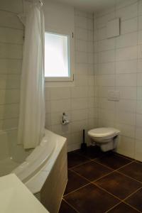 a bathroom with a tub and a toilet and a window at Andromède, appartements 2 à 5p de standing in Moleson