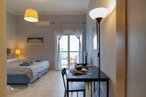 雅典的住宿－'Afrodite' Central Cozy Studio In Egaleo，卧室配有1张床、1张桌子、1张床和1张桌子及椅子