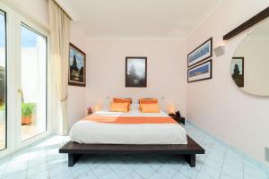 a white bedroom with a large bed with orange pillows at Starhost - Villa il Poggio Amalfi Coast in Vietri