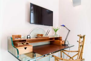 a glass desk with a television on a wall at Starhost - Villa il Poggio Amalfi Coast in Vietri