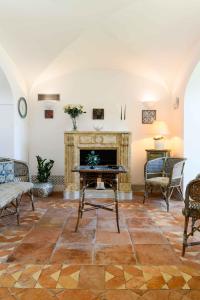 a living room with a fireplace and chairs at Starhost - Villa il Poggio Amalfi Coast in Vietri
