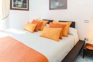 a bed with orange pillows on it in a room at Starhost - Villa il Poggio Amalfi Coast in Vietri