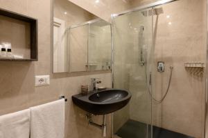 ein Bad mit einem Waschbecken und einer Dusche in der Unterkunft DolceVitaSuite in Rom