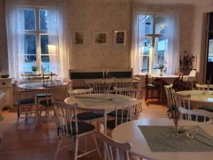 a dining room with tables and chairs and windows at Sofielund Vandrarhem & Camping in Sala