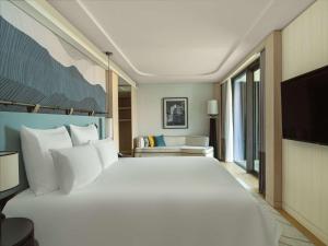 a hotel room with a large bed and a television at Swissotel Resort And Spa Cesme in Cesme