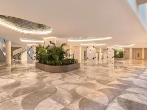 een lobby met een marmeren vloer en planten bij Swissotel Resort And Spa Cesme in Çeşme