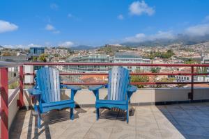 two blue chairs and a table on a balcony at Funchal Marina Bay in Funchal