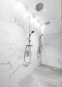 a bathroom with white marble walls and a shower at Oru Villa, LUXURY 3 BR APARTMENT, SAUNA, BEACH in Viljandi