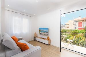 罗克布吕讷-卡普马丹ORCHIDÉES - SPLENDIDE 2 Pièces - PARKING - 50 m BORD DE MER的带沙发的白色客厅和阳台