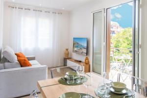 罗克布吕讷-卡普马丹ORCHIDÉES - SPLENDIDE 2 Pièces - PARKING - 50 m BORD DE MER的客厅里有一张沙发和一张桌子。