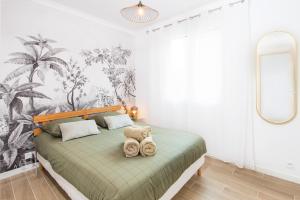 罗克布吕讷-卡普马丹ORCHIDÉES - SPLENDIDE 2 Pièces - PARKING - 50 m BORD DE MER的一间卧室,配有一张绿床,里面装满了动物