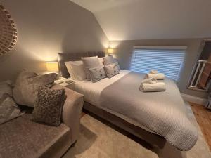 a bedroom with a large bed and a couch at The Gatehouse, Bijou studio apartment - sleeps 2 in Easingwold