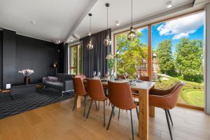 a dining room with a table and chairs at Oru Villa, LUXURY 3 BR APARTMENT, SAUNA, BEACH in Viljandi +20 photos