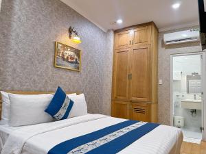 Schlafzimmer mit einem Bett und einem Holzschrank in der Unterkunft Tra My Hotel - SaiGon Center in Ho-Chi-Minh-Stadt