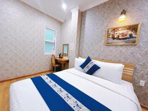 ein Hotelzimmer mit einem Bett und einem Schreibtisch in der Unterkunft Tra My Hotel - SaiGon Center in Ho-Chi-Minh-Stadt