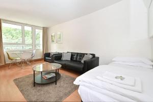 a bedroom with a bed and a couch and a table at Regents Park- UCL, Apartment with Balcony in London