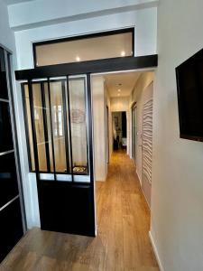 a hallway with a glass door in a house at T3 moderne et climatisé - Plages à pied - PARKING GRATUIT in Vallauris