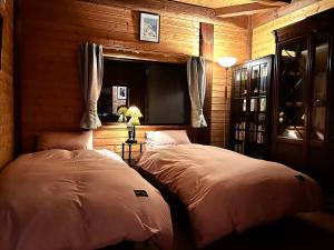 1 dormitorio con 2 camas en una habitación con paredes de madera en beau lac biwako en Takashima