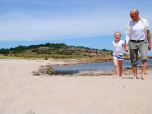 a man and a girl walking on the beach at 4 person holiday home in Allinge in Allinge