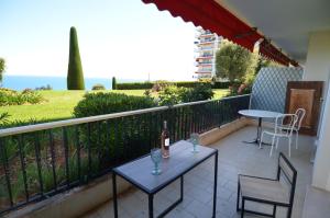 - Balcón con mesa, 2 sillas y botella de vino en Exceptionnel studio vue Mer hauteurs de Nice, en Niza