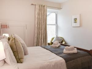 Belmont Apartment في أرنسايد: غرفة نوم مع سرير مع اثنين من الحيوانات المحشوة عليه