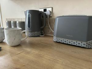 a counter with two coffee cups and a toaster at Ennerdale Edge - 4 Bed House in Cleator Moor