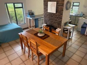 a kitchen and dining room with a wooden table and chairs at Pondjiebotter in Pringle Bay