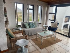 a living room with a couch and a glass table at Pondjiebotter in Pringle Bay