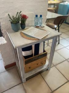 a table with a book and two bottles of water on it at Pondjiebotter in Pringle Bay