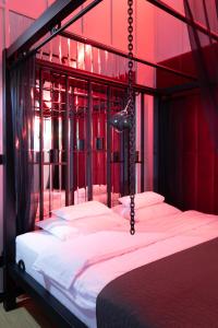 1 dormitorio con 1 cama grande y paredes rojas en Exclusive BDSM Apartment Kraków - ADULTS ONLY en Cracovia