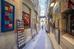 a narrow alley in a city with people walking down it at La Carterie, Beau T1 mez, Clim, Centre historique in Montpellier