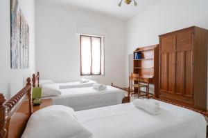 3 camas en una habitación con paredes blancas y ventana en Spacious House in Sinis, en Cabras