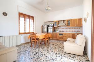 Una cocina con mesa de comedor y sillas. en Spacious House in Sinis, en Cabras